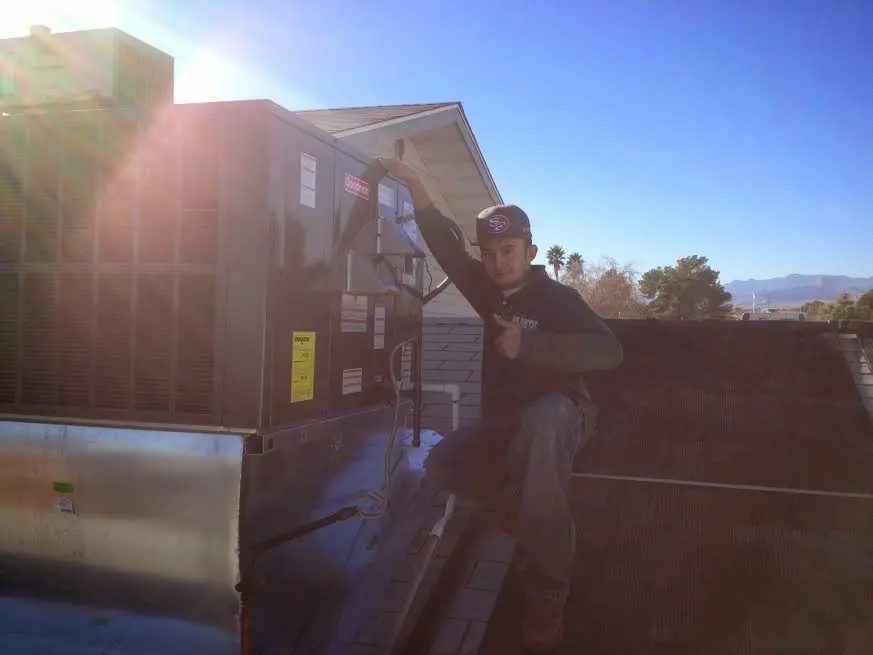HVAC technician performing Air Duct Cleaning on a rooftop unit in Madison